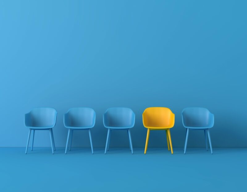 Cinco sillas, cuatro de ellas son del mismo color azul, idéntico tono al del suelo y pared; la silla diferente, es amarilla y refleja el sentimiento y realidad de ser la única persona en la sala.