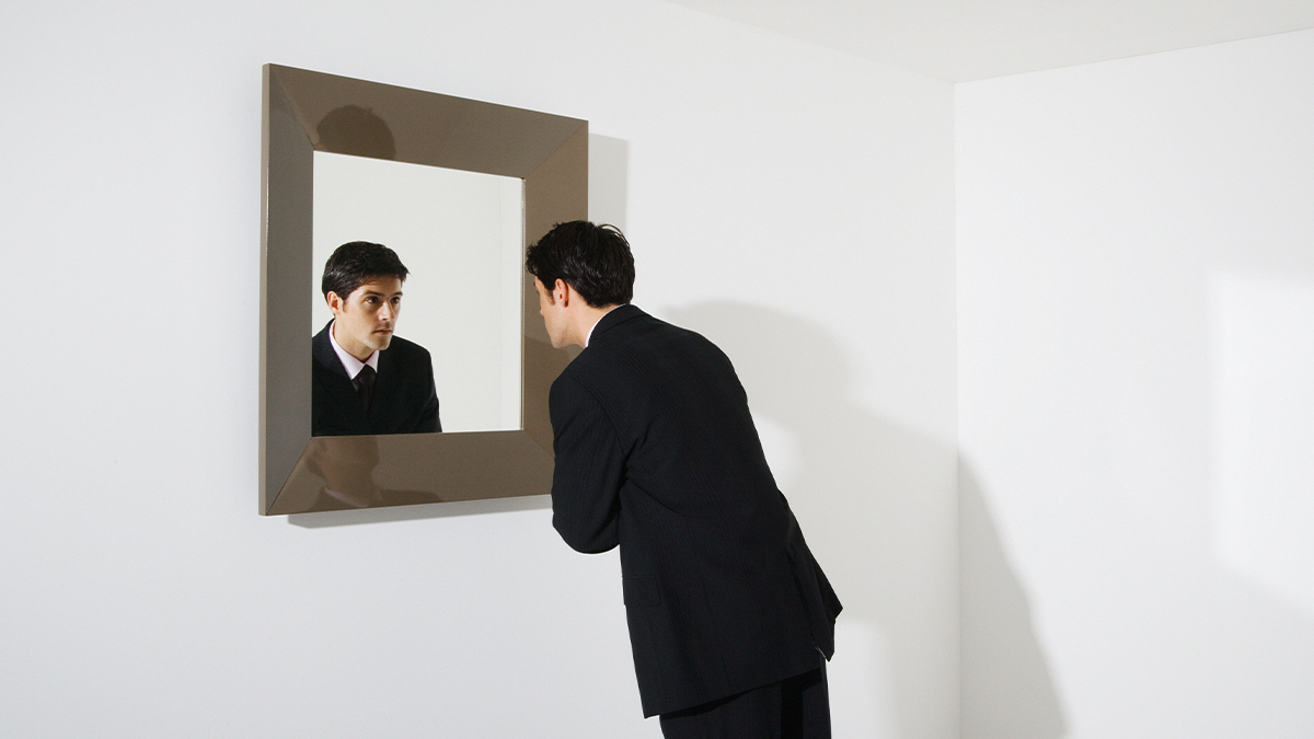 Hombre observándose al espejo egocéntricamente